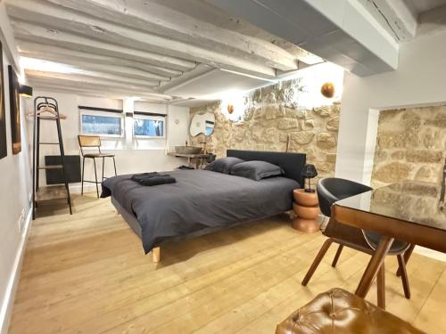 une chambre avec un lit et un mur en pierre dans l'établissement MONA LiSA - 110 m2 Luxury flat in Le Marais - AC, à Paris