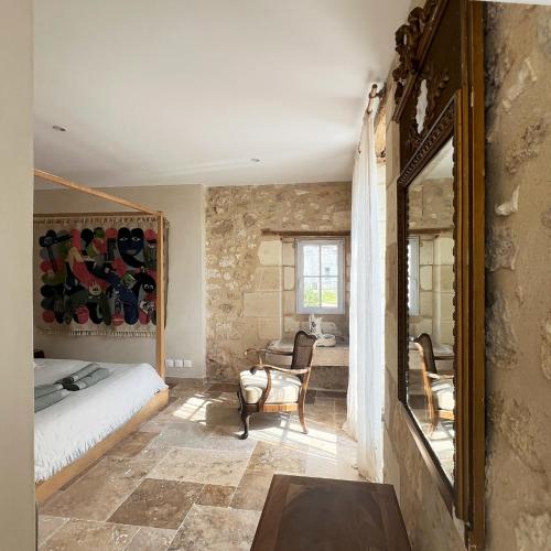 une chambre avec un lit et un miroir dans l'établissement Gîte - LA CLOCHETTE, à Lugon et l’Ile du Carney