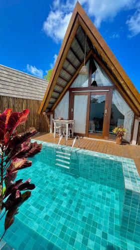a house with a swimming pool in front of it at Pousada Villa di Luna in São Miguel do Gostoso
