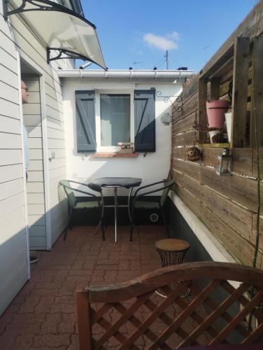 un petit patio avec une table et un banc dans l'établissement La plume, à Abbeville