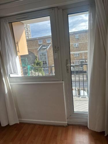 an empty room with a door and a window at London Budget Maisonette in London