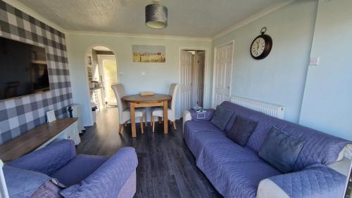 a living room with a blue couch and a table at Ranger - Snowdon Cabins holiday let Caernarfon in Caeathro