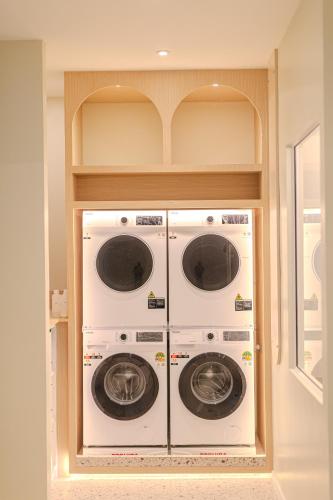 two washer and dryer machines in a room at ezzenhotel Phitsanulok in Phitsanulok