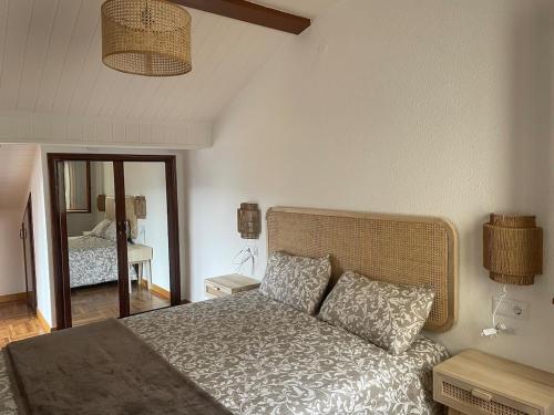 a bedroom with a bed and a mirror at Magnifico ático con vistas, parking y piscina in Puigcerdà