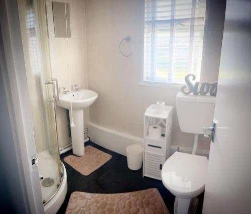 a small bathroom with a toilet and a sink at Norfolk Beach Chalet - California Sands Resort in Great Yarmouth