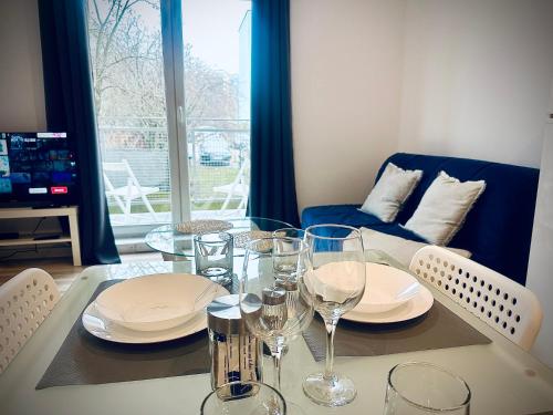 a dining room with a table with plates and wine glasses at Studio 4U - Aquapark Reda in Reda