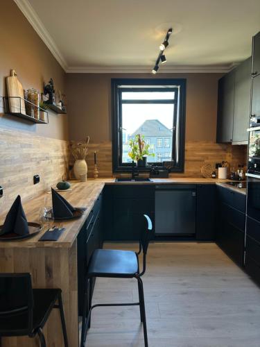 a kitchen with black cabinets and a window at A Place To Stay Stavanger, apartment 6 in Stavanger
