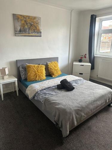 a bedroom with a bed with yellow pillows on it at London Budget Maisonette in London