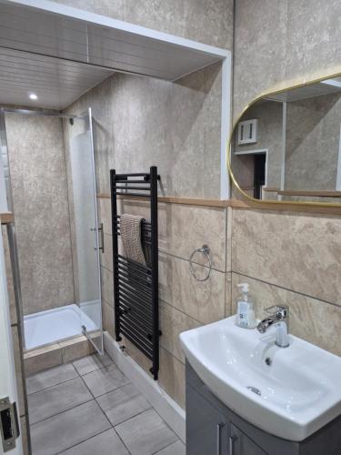 a bathroom with a sink and a mirror at Ulverston Town Centre Ground Floor Apartment in Ulverston