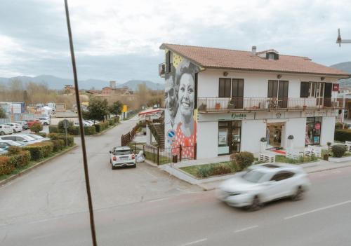 a white car driving down a street next to a building at Homy di Mei in Narni Scalo