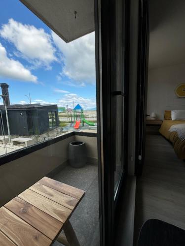 a room with a balcony with a bed and a table at Apartment By Toore Patagonia in Puerto Natales