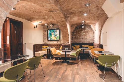 a room with chairs and tables and a brick wall at Fortune boutique old town in Poznań