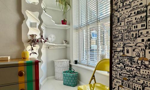 a bathroom with a shower curtain with a yellow chair at Zen Beach House in Kent