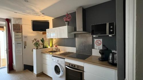 Il comprend une cuisine équipée d'un lave-linge et d'un sèche-linge. dans l'établissement Goeland 1, classé, climatisé, wifi terrasse ombragé de 12 m2 à 150 m de la plage, à Toulon