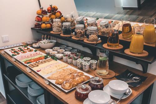 ein Buffet mit vielen verschiedenen Speisen und Getränken in der Unterkunft Fortune boutique old town in Posen