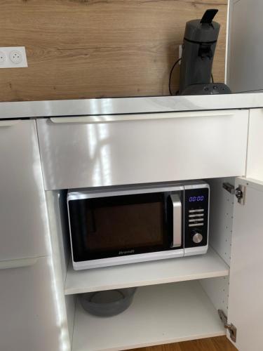 a microwave oven on a shelf in a kitchen at La belle vue in Béziers