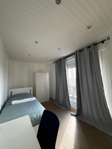 une chambre avec un lit et une grande fenêtre dans l'établissement Mantes-la-Jolie Apartment 8p, à Mantes-la-Jolie