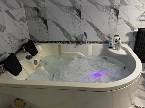 a bath tub filled with water in a bathroom at Muz in Filiaşi