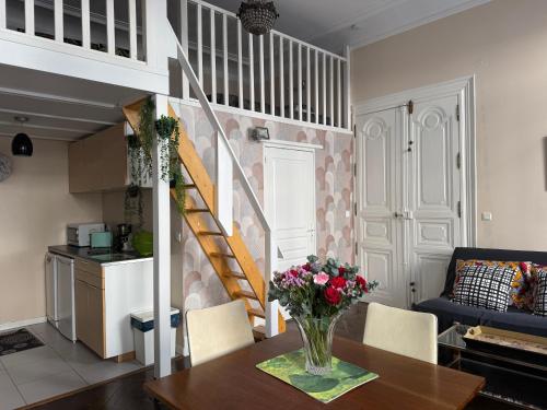 un salon avec un vase de fleurs sur une table dans l'établissement Studio 30 m2 avec jardin dans maison de maître, à Béziers