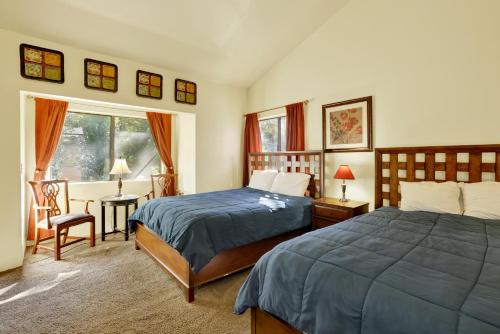 a bedroom with two beds and a table and a window at Buttercup Snow Summit Condo by Big Bear Vacations in Big Bear Lake