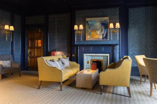 a living room with two chairs and a fireplace at Lindeth Fell Country House in Bowness-on-Windermere