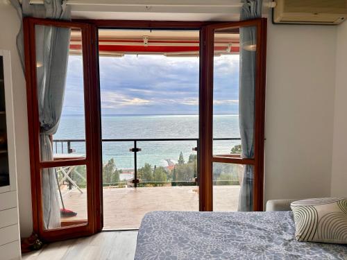 a bedroom with a door open to a view of the ocean at OSPEDALETTI Mare e Relax- Affittasi "Oasi Riviera" con campo da Tennis e Sala Giochi in Ospedaletti