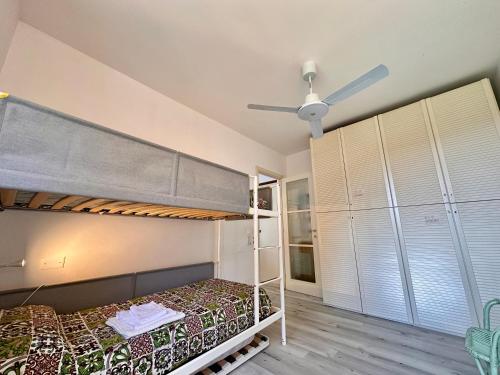 a bedroom with bunk beds and a ceiling fan at OSPEDALETTI Mare e Relax- Affittasi "Oasi Riviera" con campo da Tennis e Sala Giochi in Ospedaletti