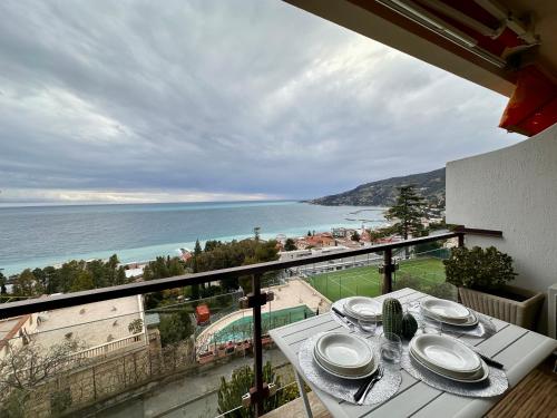 a balcony with a table with a view of the ocean at OSPEDALETTI Mare e Relax- Affittasi "Oasi Riviera" con campo da Tennis e Sala Giochi in Ospedaletti