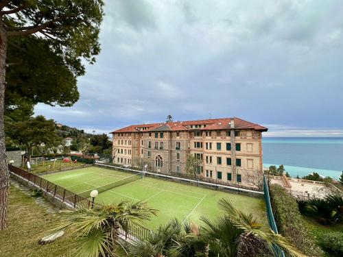 a building with a tennis court in front of it at OSPEDALETTI Mare e Relax- Affittasi "Oasi Riviera" con campo da Tennis e Sala Giochi in Ospedaletti