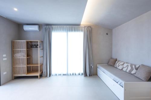 a living room with a couch and a large window at Oikos Rooms in Marsala