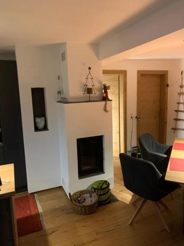a living room with a fireplace and a chair at Haus Cäcilia in Sankt Martin bei Lofer