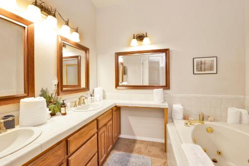 a bathroom with two sinks and a tub and a bath tub at Modern Luxury Retreat - Sacred Stone Big Bear in Big Bear Lake