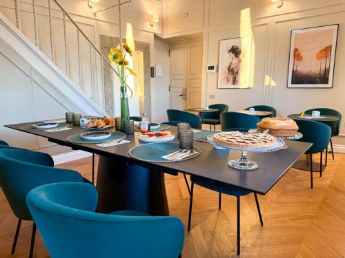 een eetkamer met een tafel en blauwe stoelen bij Corte Sospesa Guest House & Spa in Bassano Romano