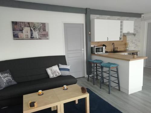 un soggiorno con divano e cucina di Maison entre Seine et forêt a Aizier