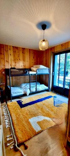 une chambre avec deux lits superposés et un tapis dans l'établissement Charmante maison en bois- Lège Cap ferret, à Lège-Cap-Ferret