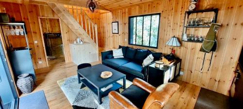 un salon avec un canapé bleu et une table dans l'établissement Charmante maison en bois- Lège Cap ferret, à Lège-Cap-Ferret