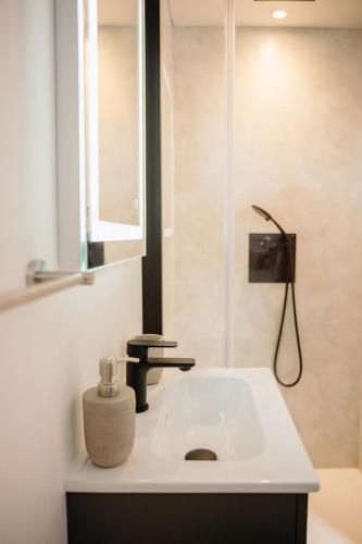 a bathroom with a sink with a soap dispenser on it at Chez Lilie in Le Sel