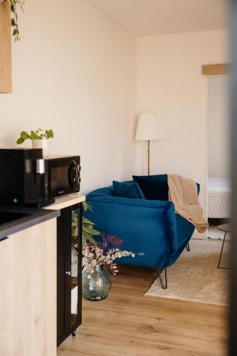 a living room with a blue couch in a living room at Chez Lilie in Le Sel