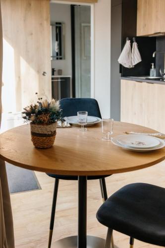 a wooden table with two plates and a plant on it at Chez Lilie in Le Sel