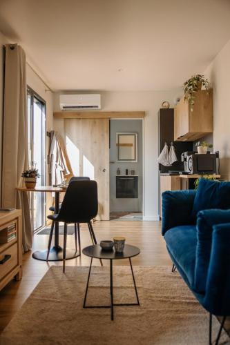 a living room with a blue couch and a table at Chez Lilie in Le Sel