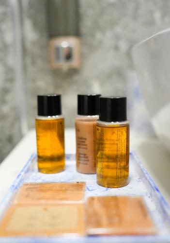 three bottles of essential oils sitting on a table at Le prince Rooms in Tirana