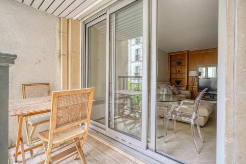 un salon avec une table et des chaises et une salle à manger dans l'établissement Spacious & Cozy Apartment - Trocadero Passy, à Paris