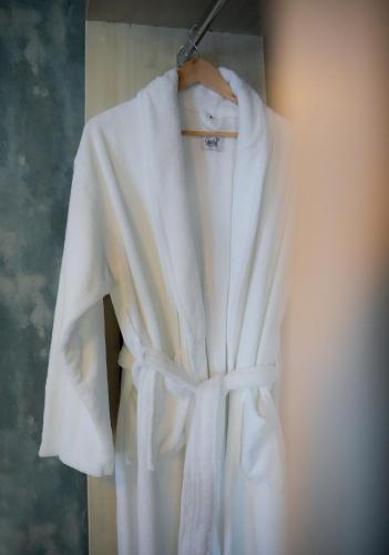 a white robe is hanging on a hanger at Le prince Rooms in Tirana