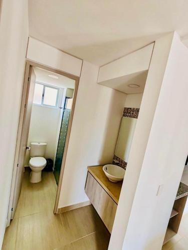 a bathroom with a toilet and a sink and a mirror at Ciudad Cristales in Villeta
