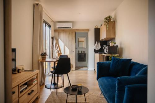 a living room with a blue couch and a table at Chez Lilie in Le Sel