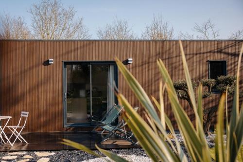 a house with a sliding glass door and two chairs at Chez Lilie in Le Sel