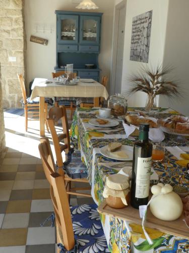 a dining room with a table with food and wine at Agriturismo Fondo Paliemmu in Modica