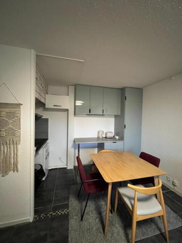 une cuisine avec une table en bois et deux chaises dans l'établissement Appartement rénové au Penon, à Seignosse