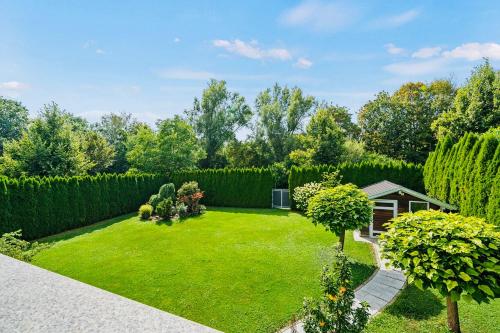 a garden with a green lawn and trees at The Villa Toscana, a serene retreat in Center of Friedrichshafen City with lush green lawns, terrace & private garage- Lidl, Bakery walking distance- Bodenseecenter, Sportsbad 3 mins, Lake 7 mins in Friedrichshafen