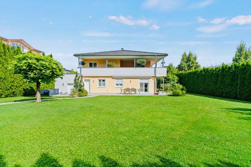 a large yard in front of a house at The Villa Toscana, a serene retreat in Center of Friedrichshafen City with lush green lawns, terrace & private garage- Lidl, Bakery walking distance- Bodenseecenter, Sportsbad 3 mins, Lake 7 mins in Friedrichshafen